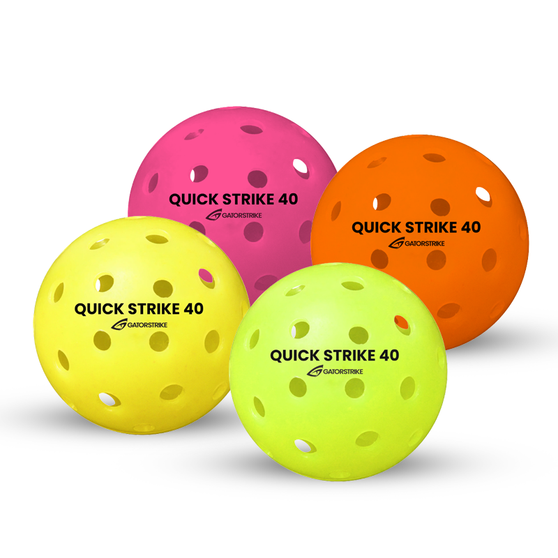Four perforated plastic balls in pink, orange, yellow, and light green, each labeled “QUICK STRIKE 40 GA ADORSTRIKE,” are arranged in a group on a white background.