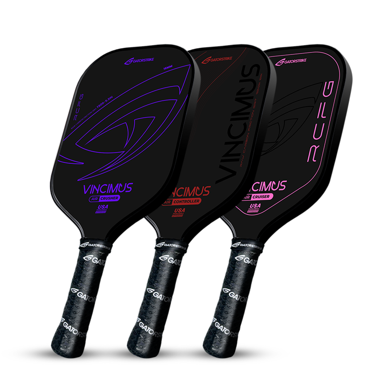 Three black pickleball paddles with different neon accents—blue, purple, and pink—stand upright side by side. Each paddle has a textured black grip and bold, curved designs.