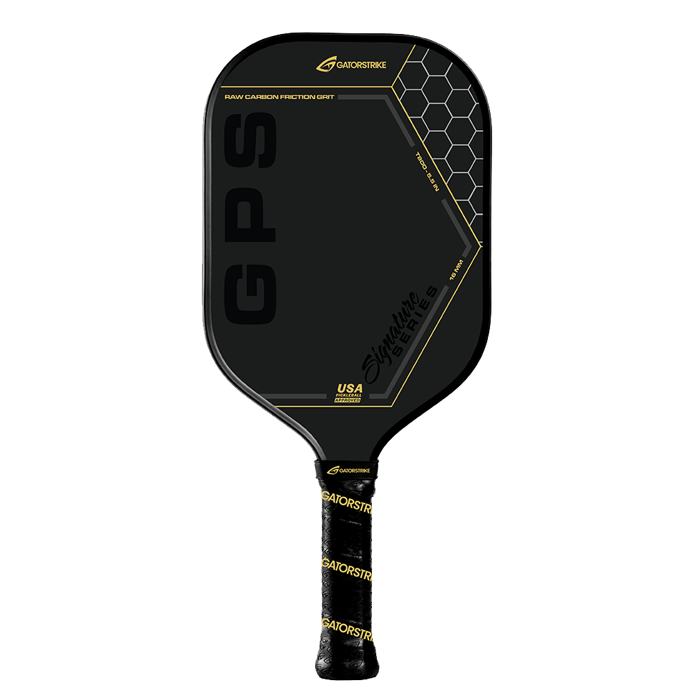 A black carbon fiber pickleball paddle with gold accents, labeled “GPS.” The upper right shows a honeycomb pattern and “GATORSTRIKE” branding. The grip has anti-vibration foam and black tape with gold “GATORSTRIKE” text. Plain white background.