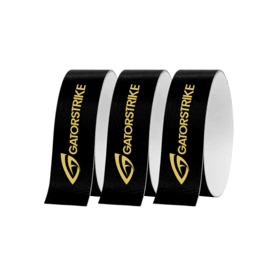 Three rolls of GATORSTRIKE black protective tape are placed side by side, each featuring bold yellow GATORSTRIKE branding and logo. The tape has a white inner side and provides durable protection for paddle edges.